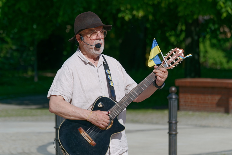6 - An elderly man performing as a street musician in a public park